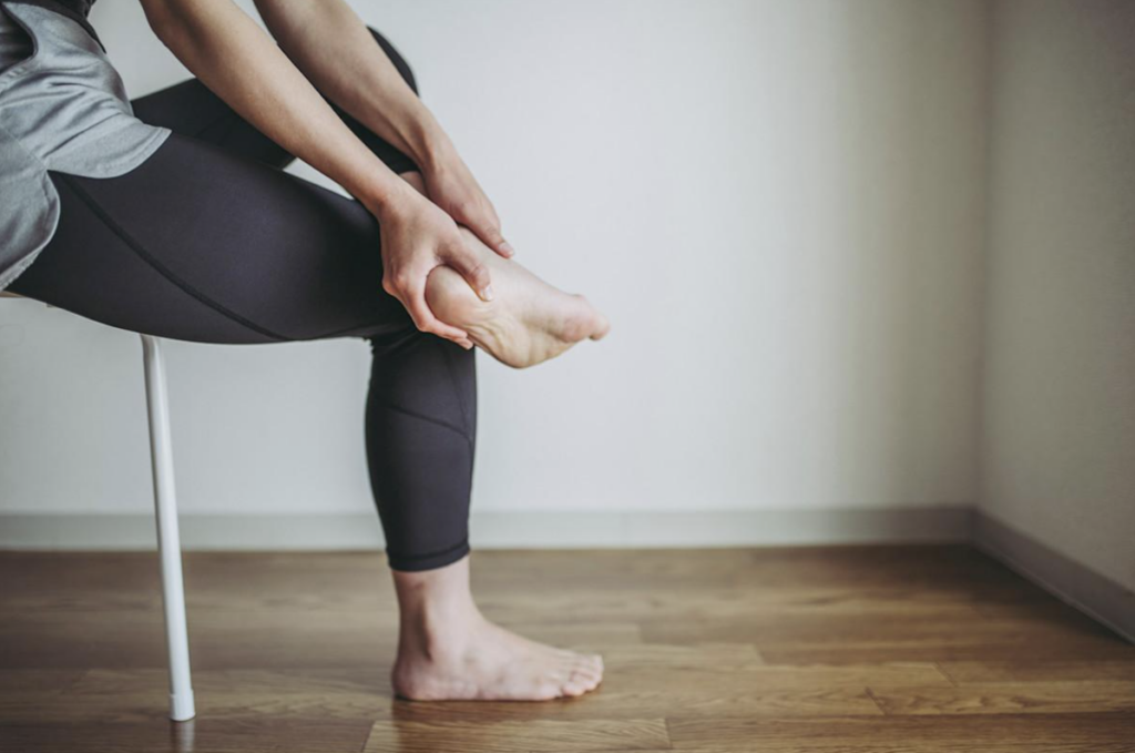 An image of someone doing a plantar fascia stretch while sat down.